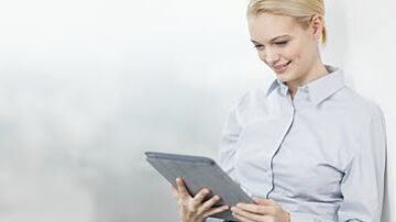 Frau hält ein Tablet in ihren Händen