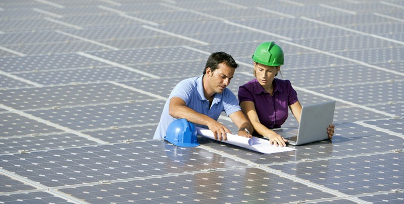 Green Startup Report 2026: Grünes Gründen bleibt auf Wachstumskurs Ein Mann und eine Frau stehen mit Laptop und Unterlagen auf einem Solarfeld - Link auf Seite: Green Startup Report 2026: Grünes Gründen bleibt auf Wachstumskurs