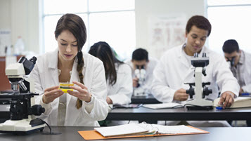 Mehrere Personen arbeiten an Mikroskopen in einem Labor