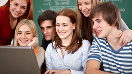 Ein Gruppe von Schülern schaut auf einen Laptop; Link zur Seite Unternehmergeist für Schüler
